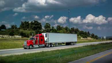 Red reefer truck on highway under blue sky