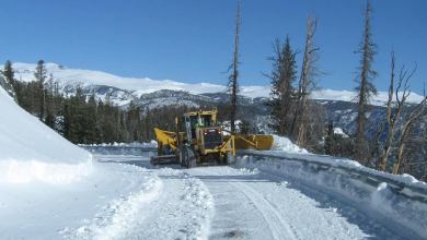 Plow clearing snowy highway in Montana.