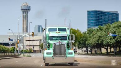 Front view of sea green truck driving on empty city street