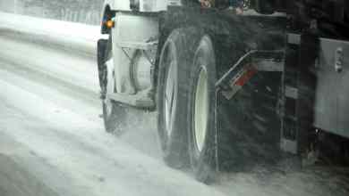 Tractor-trailer heading down slushy/icy road.