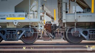 A photograph of two railcars connected to each other and parked in a rail yard.