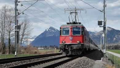 A photograph of a train on a track. The train is connected to catenaries.