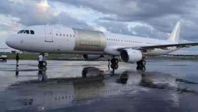 A white plane with a new cargo door installed as part of conversion to a freighter.