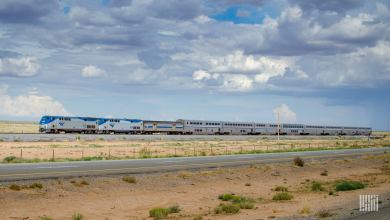 A photograph of an Amtrak train crossing a desert field.