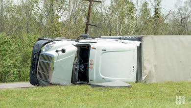 Tractor-trailer tipped over on side of a road.