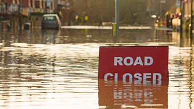 Flooded road with "Road Closed" sign.