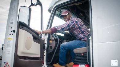 A truck driver gets in the cab of a truck