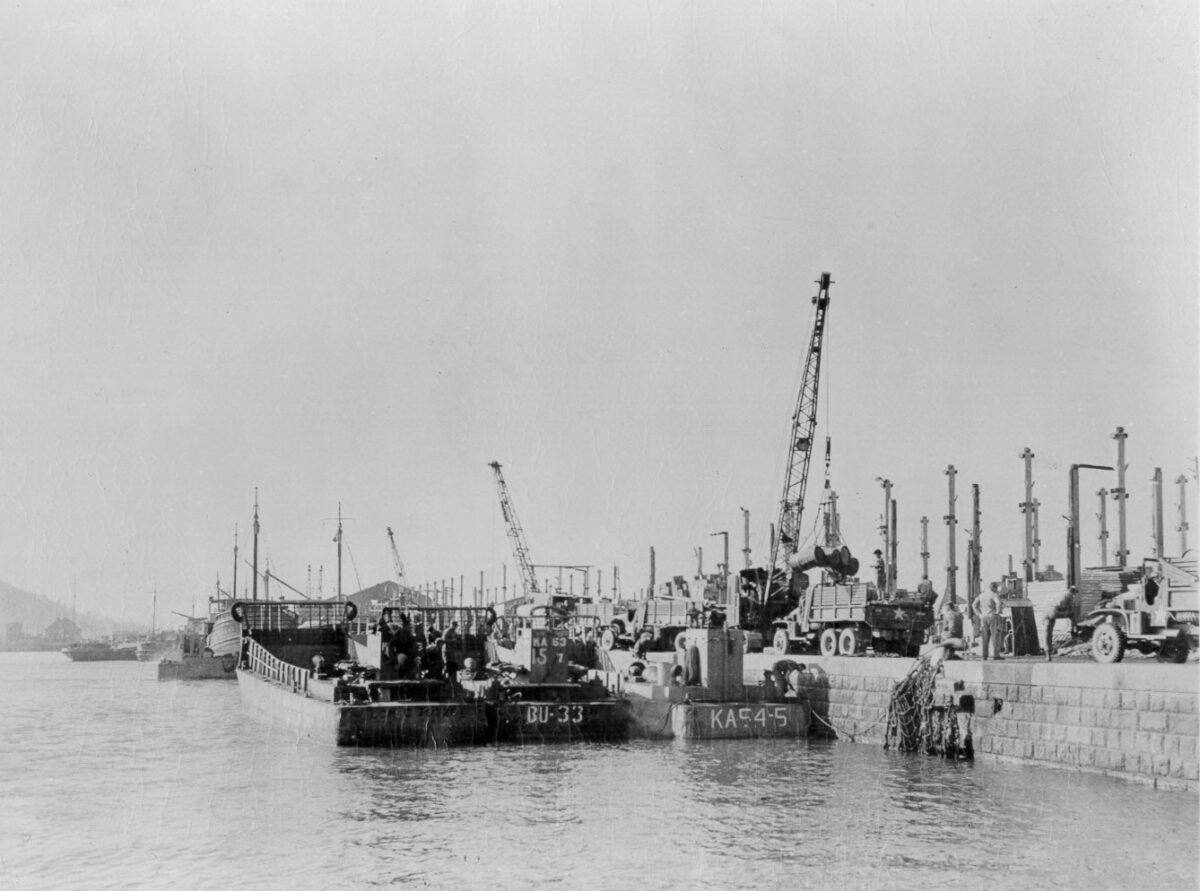 Cranes loading ships during Korean War at Inchon inner harbor. 