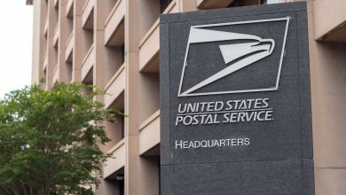 Close up photo of the U.S. Postal Service HQ building and sign.