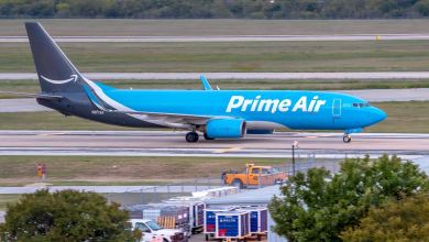 Light-blue Prime Air cargo jet with dark-blue tail and Amazon logo on a taxiway.