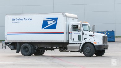 A side view of a large USPS truck.