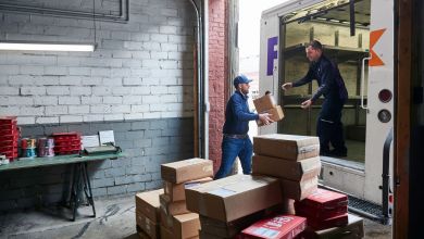 A dockworker loads packages into a FedEx van.
