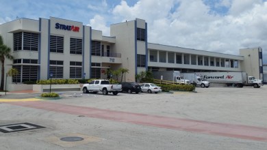 Front view of the StratAir warehouse with a Forward Air truck at the dock.