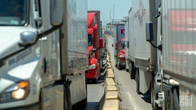 Image of trucks in a line that may be impacted by an immediate pause to the issuing of worker visas for commercial truck drivers