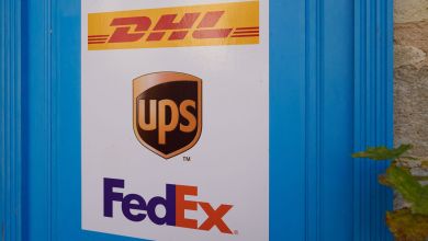 A close up of sticker showing DHL, UPS and FedEx logos at an independent package shipping outlet.