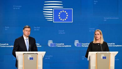 A man at a podium, left, and a woman at podium, right, speak at an EU ministerial forum with a blue EU background.