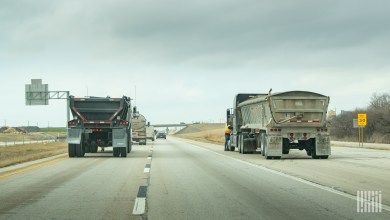 Two dump trailers being pulled on a highway