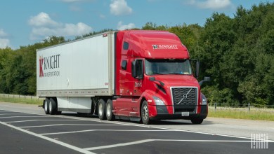 a red Knight Transportation tractor pulling a white Knight trailer on a highway