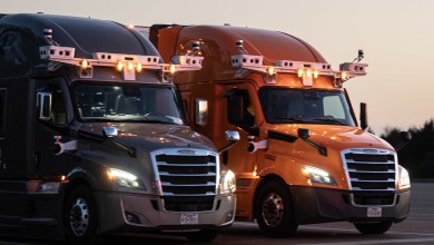 Bot Auto autonomous Freightliner trucks with rooftop sensor arrays parked side by side at dusk, ready for driverless freight operations between Houston and Dallas