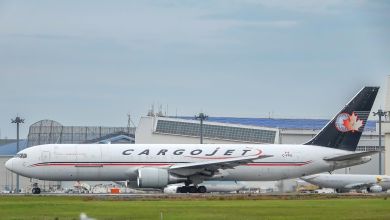 A blue-tailed Cargojet freighter seen at an airport on the taxiway, side view.
