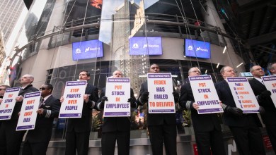 FedEx pilots stand on a picket line with signs.