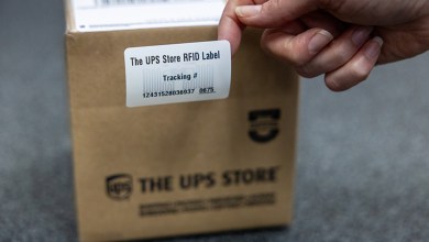 A person affixes an RFID tracking label to a parcel.