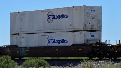 STG containers double-stacked on a well car