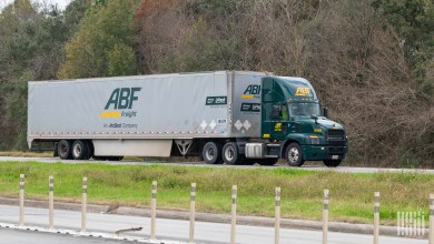 A green ABF daycab pulling a 53-foot fryvan trailer on a highway