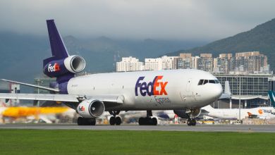 A purple-tailed FedEx plane ready for takeoff as seen from front angle.