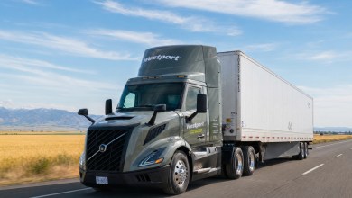 Westport’s Volvo VNL heavy-duty semi-truck with white trailer driving on a rural Idaho highway, golden fields and mountains in the background under a clear blue sky