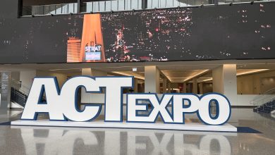 ACT Expo 2026 large white 3D sign with blue outline displayed inside a modern convention center, with a digital screen showing the Las Vegas STRAT tower at night in the background.