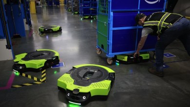 Green-and-black robotic saucers are moving carts of packages in Amazon fulfillment centers.