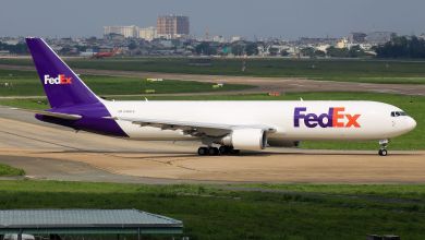 A purple-tail FedEx cargo jet prepares turns onto runway at an airport in Vietnam.