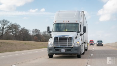 a white sleeper cab pulling a white trailer on the highway