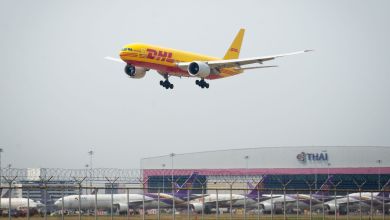 A yellow DHL cargo plane makes its final approach to Bangkok airport in Thailand.